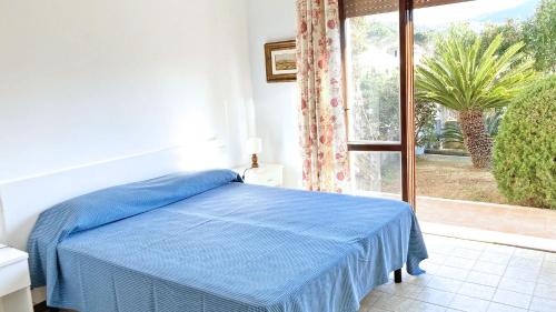 ein Schlafzimmer mit einem blauen Bett und einem großen Fenster in der Unterkunft Villa Solana - ArgonautiVacanze in Portoferraio