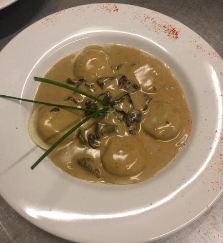 a bowl of food with mushrooms on a white plate at Terrazas Del Calafate in El Calafate