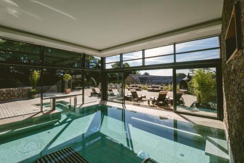 a swimming pool in a house with a large window at Boringdon Hall Hotel and Spa in Plymouth