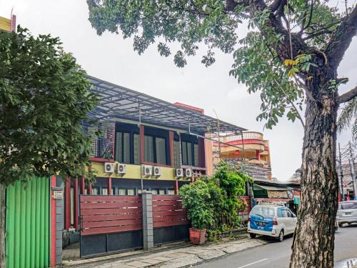 a building on the side of a street with a tree at Penginapan Marsya Prima Syariah in Jakarta