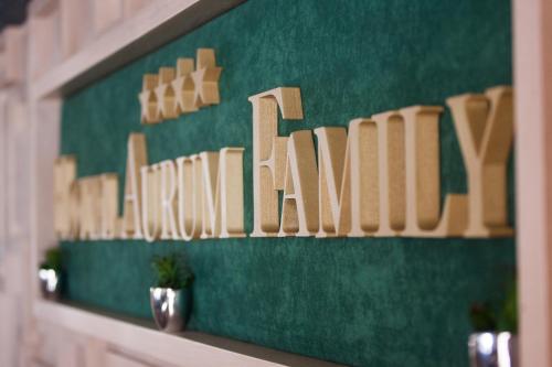 a green wall with a library sign on a shelf at Hotel Aurum Family "A" in Hajdúszoboszló