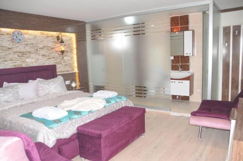 a bedroom with a purple bed and a purple couch at Hotel Goreme Sakura in Pamukkale