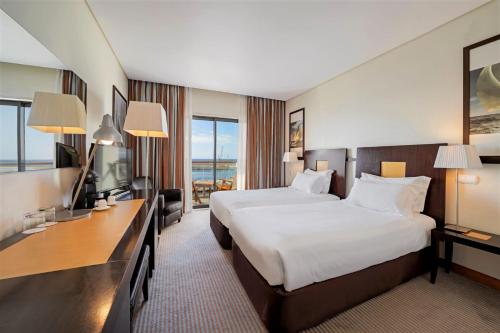 a hotel room with a large bed and a television at Hotel Marina Atlântico in Ponta Delgada