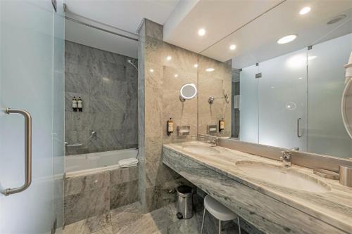 a large bathroom with a large sink and a tub at Hotel Marina Atlântico in Ponta Delgada