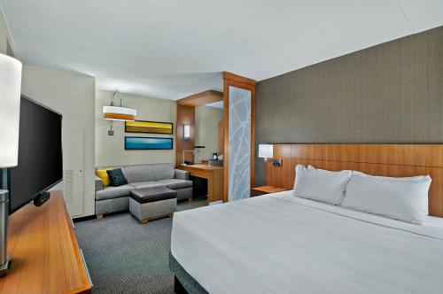 a hotel room with a bed and a couch at Hyatt Place Fredericksburg at Mary Washington in Fredericksburg