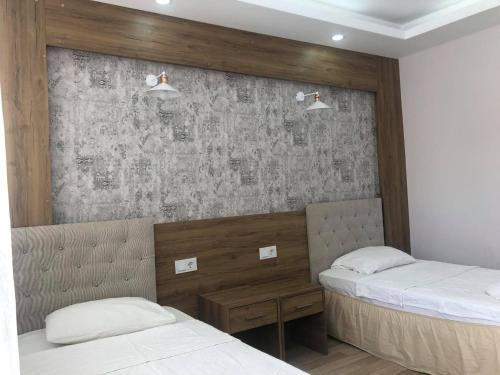 a bedroom with two beds and a wall at Hotel Goreme Sakura in Pamukkale