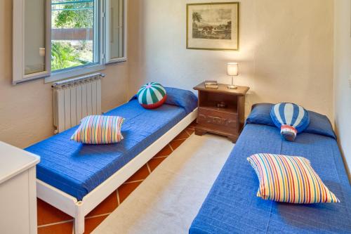 two beds in a room with blue sheets and pillows at PORTOVECCHIO in Levanto
