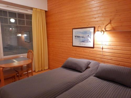 um quarto com uma cama, uma mesa e uma secretária em Lapin Kutsu Luulampi Apartments em Saariselka