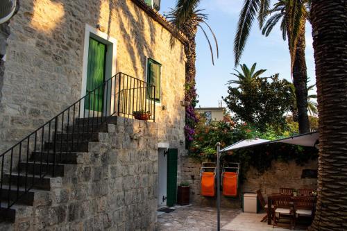 a stone building with a staircase next to a patio at Villa Cindro House in Podstrana