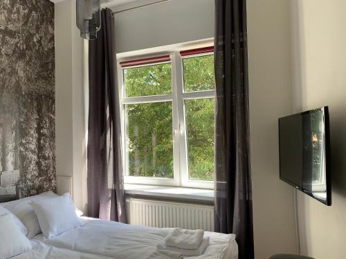 a bedroom with a bed and a window at VULTOR Apartments in Wrocław