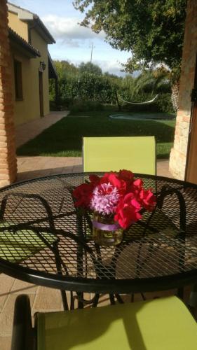 a table with a vase of flowers on it at Agriturismo La Vecchia Fonte in Castelbellino