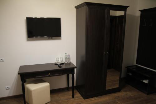 a room with a desk and a television and a cabinet at Купецький Двір in Mizhhirʼʼya