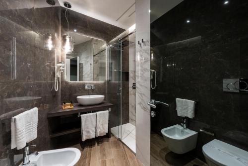 a bathroom with a sink and a toilet and a shower at Growel Exclusive Suites San Pietro in Rome