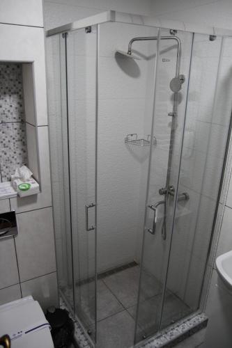 a shower with a glass door in a bathroom at Купецький Двір in Mizhhirʼʼya