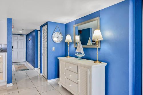 a hallway with blue walls and a clock on the wall at Van Lee 1203 in Ormond Beach