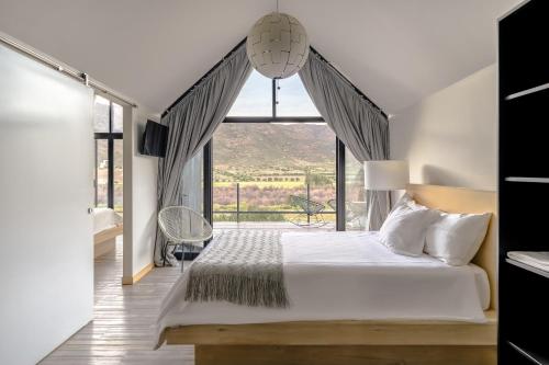 a bedroom with a bed and a window at Oeno Wine Lodge in Valle de Guadalupe