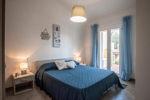 una camera con un letto blu e una finestra di Villa Girasole a Valledoria