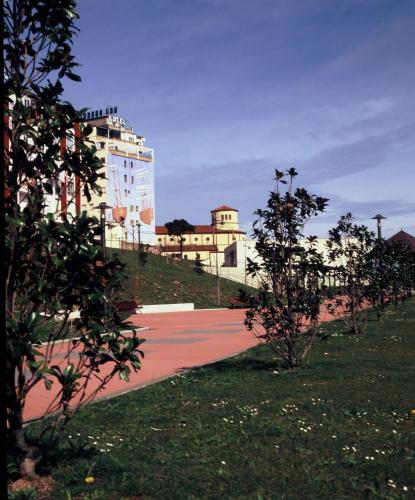 a park with trees and a building in the background at Hotel Las Anclas in El Astillero