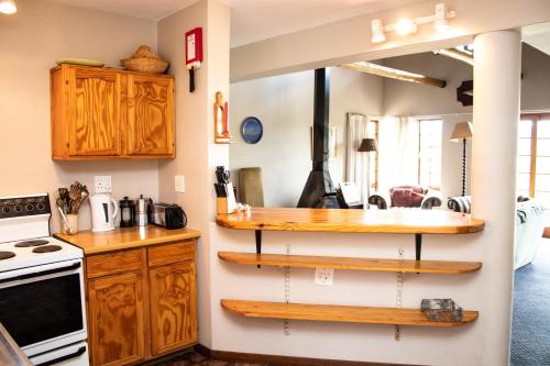 una cocina con estanterías de madera en la pared en Graceland Farm, en Underberg