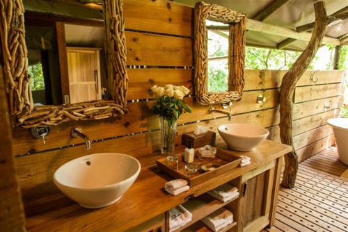 a bathroom with two sinks and two mirrors at Summerfields Rose Retreat and Spa in Hazyview
