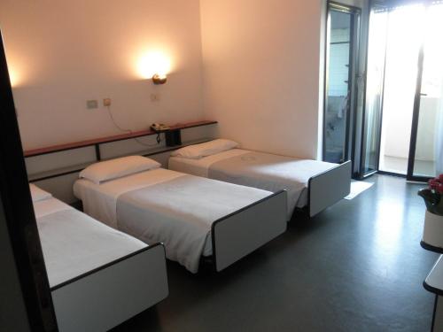 a room with three beds in a room at Park Hotel in Castrocaro Terme