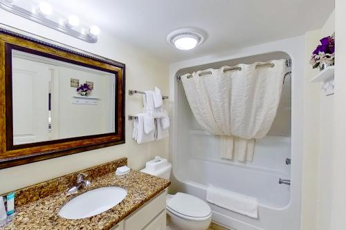 a bathroom with a sink and a toilet and a mirror at Bay Watch 1941 in Myrtle Beach
