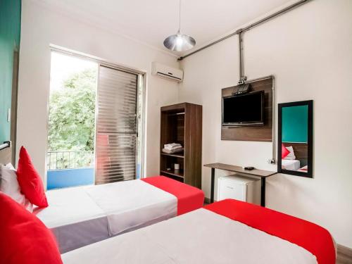 Habitación de hotel con 2 camas y TV en MOVA 104 - Hotel Consulado Avenida Paulista, en São Paulo