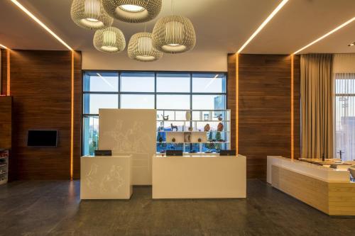 a lobby with a reception desk and large windows at Fiesta Inn Chihuahua Fashion Mall in Chihuahua