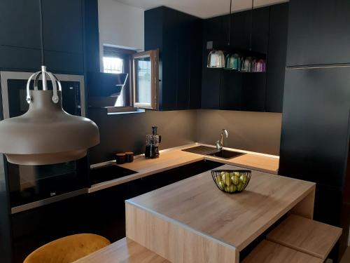 a kitchen with black cabinets and a wooden counter top at Green Bay in Baošići