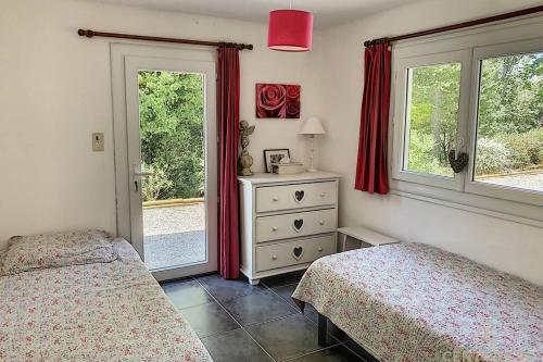 - une chambre avec 2 lits et une commode avec des fenêtres dans l'établissement Maison avec piscine chauffée entre mer et montagne, à Montauriol