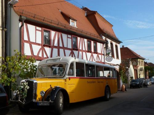 巴特迪克海姆的住宿－Pfälzer Landhotel Heinrich，停在大楼前的一辆旧黄色巴士