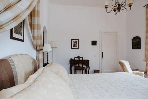a bedroom with a white bed and a table at Golf Club Metaponto in Metaponto