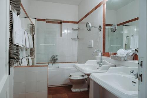 a bathroom with two sinks and a toilet and a tub at Golf Club Metaponto in Metaponto