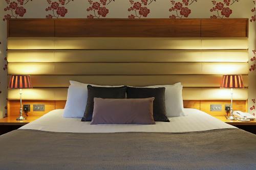 a bedroom with a large bed with a wooden headboard at Westport Country Lodge Hotel in Westport