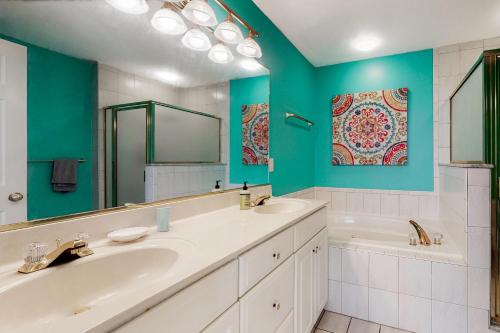 a bathroom with two sinks and a tub and a mirror at Sea Colony - 56192 Pine Branch in Bethany Beach