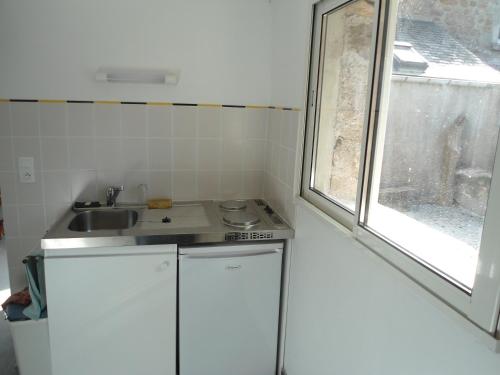 a small kitchen with a sink and a window at LA VUULE MAISON in Fermanville