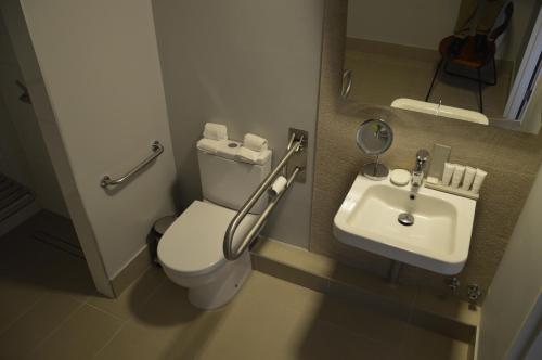 a small bathroom with a toilet and a sink at Radisson Hotel Curico in Curicó