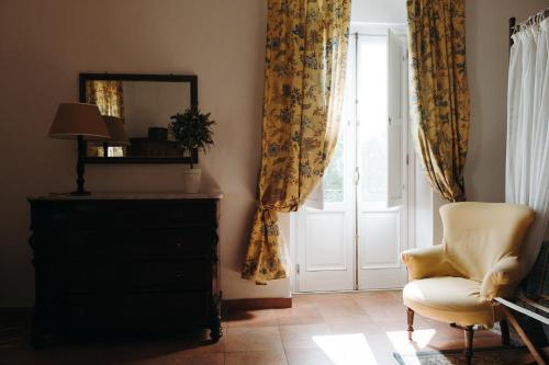 a room with a chair and a dresser and a window at Golf Club Metaponto in Metaponto
