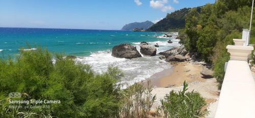 a view of a beach with rocks and the ocean at Kostas Beach Apartments in Agios Gordios