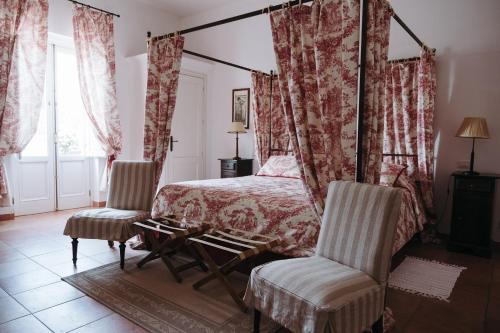 a bedroom with a canopy bed and two chairs at Golf Club Metaponto in Metaponto