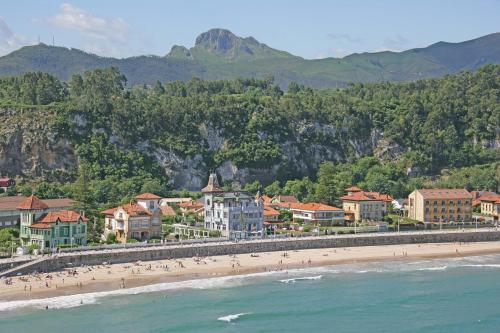 a group of people on a beach near the water at Hotel Villa Rosario, Palacete in Ribadesella