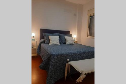 1 dormitorio con cama con sábanas azules y ventana en CALIDO CONFORTABLE Y LUMINOSO DEPTO EN PALERMO en Buenos Aires