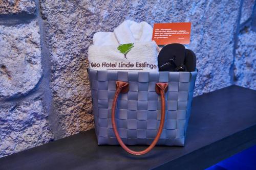 a blue basket with towels and a sign on it at Neo Hotel Linde Esslingen in Esslingen