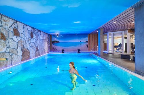 a young girl in a swimming pool at night at Neo Hotel Linde Esslingen in Esslingen
