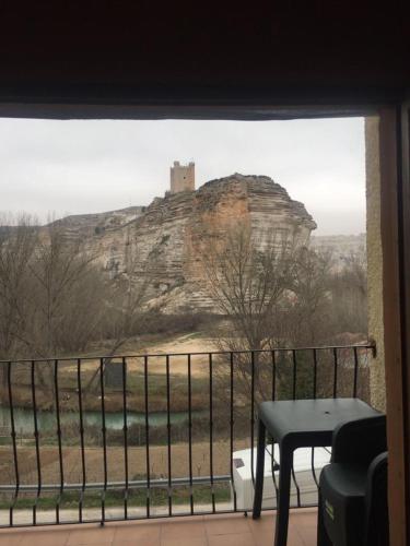 una ventana con vistas a un castillo en una colina en Casas Rurales Hoz del Júcar, en Alcalá del Júcar