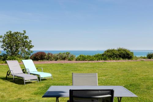 three chairs and a table in a field at La Metairie-du-Vauhariot - Vue Mer et Mont Saint Michel - Piscine Chauffée - Accès GR34 in Cancale