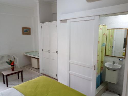 a bedroom with a bed and a sink and a mirror at Royal Palace Hotel in Santo Domingo