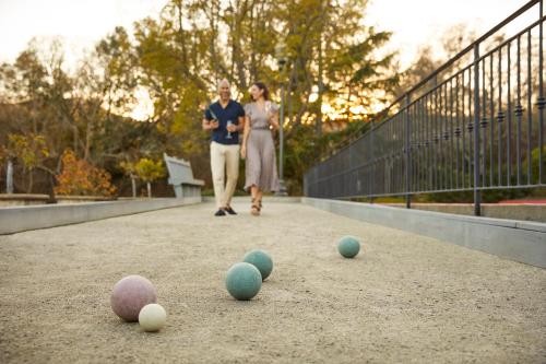 two women walking down a walkway with balls on the ground at The Estate Yountville in Yountville