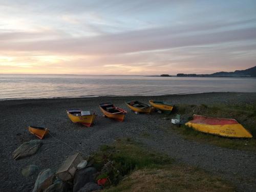 a group of canoes on a beach near the water at Cabaña frente al mar en Carretera Austral in Puerto Montt