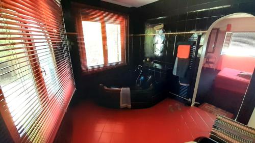 a bathroom with a toilet and a red floor at Charly Point Villa in Methoni
